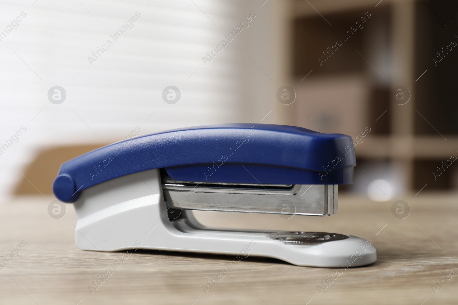 Photo of Bright stapler on wooden table indoors, closeup