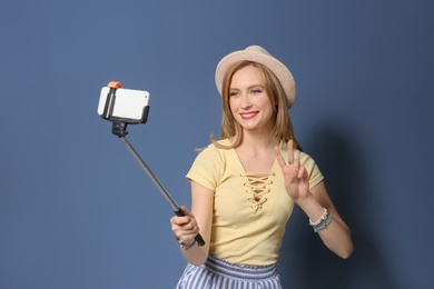 Photo of Attractive young woman taking selfie on color background