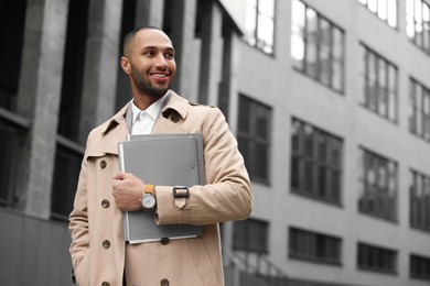 Photo of Happy man with folders outdoors, space for text. Lawyer, businessman, accountant or manager