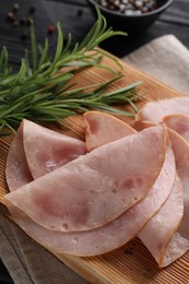 Photo of Slices of delicious ham with rosemary on table, closeup