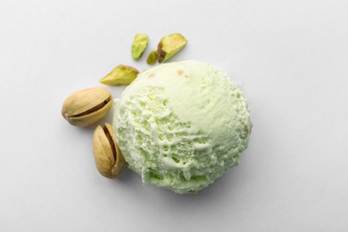 Photo of Scoop of delicious pistachio ice cream and nuts on white background, top view