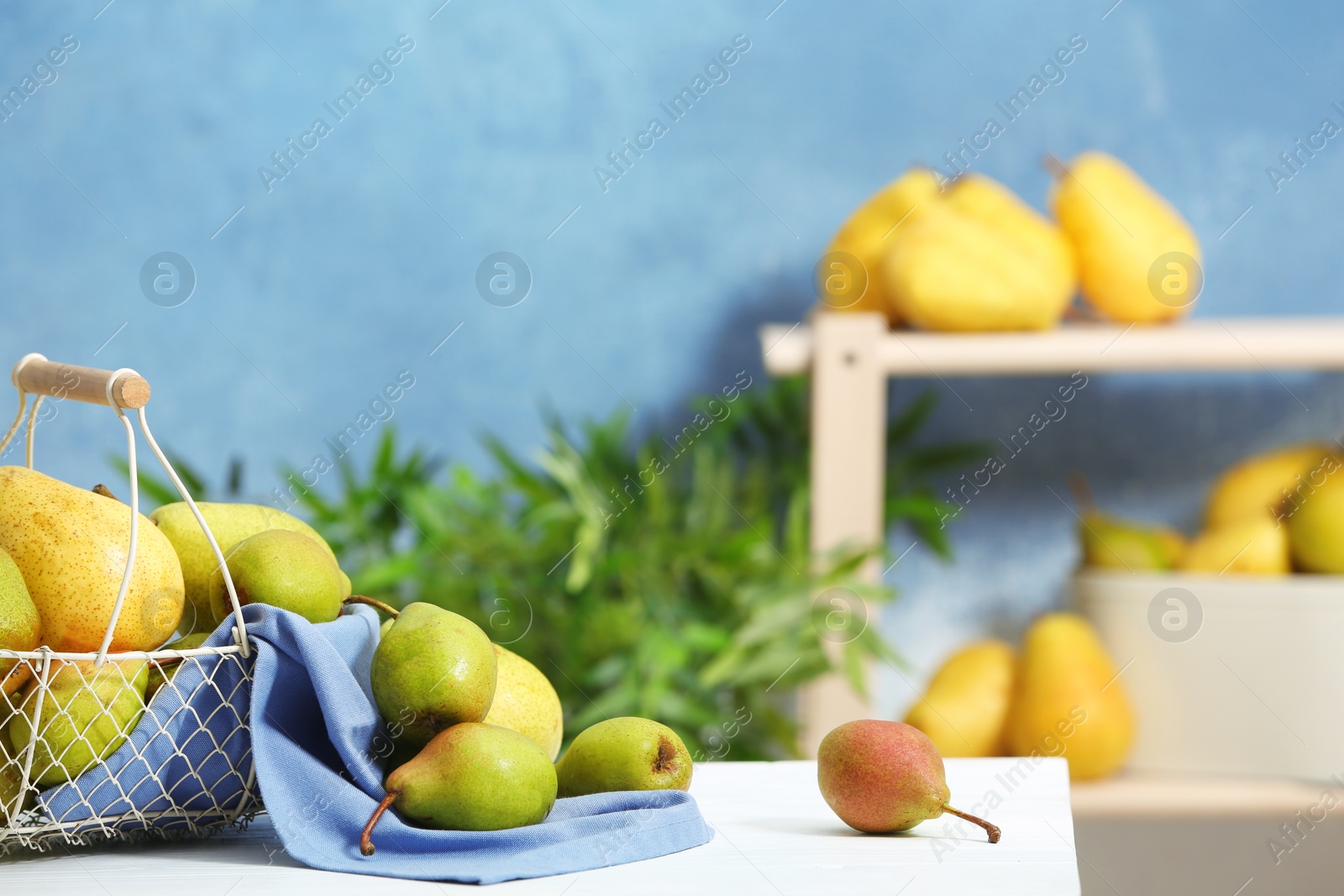 Photo of Fresh ripe pears on light table against blurred background