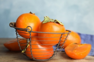 Photo of Delicious fresh persimmons on wooden table, closeup