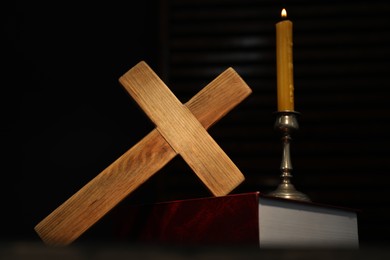 Photo of Church candle, Bible and wooden cross on table