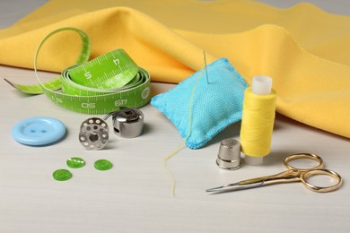 Set of sewing supplies and accessories on white table