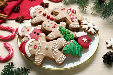 Photo of Delicious Christmas cookies, candies and fir branches on beige table