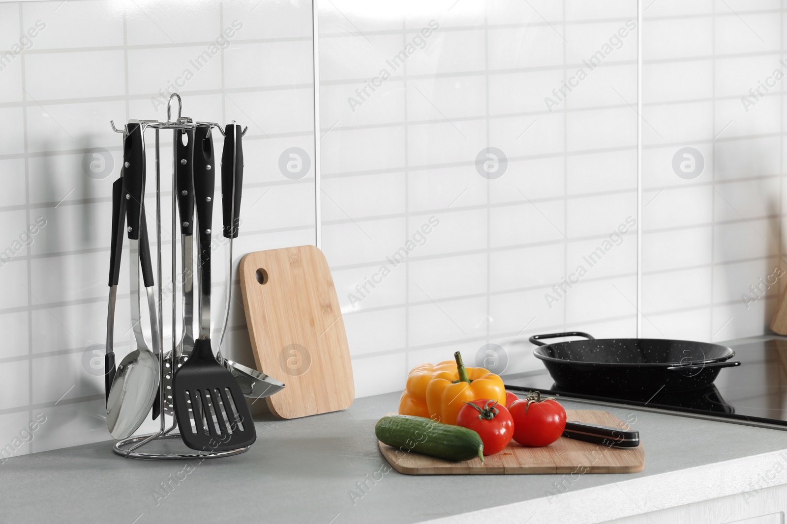 Photo of Clean cookware, vegetables and utensils on table in kitchen