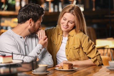 Photo of Romantic date. Lovely couple spending time together in cafe