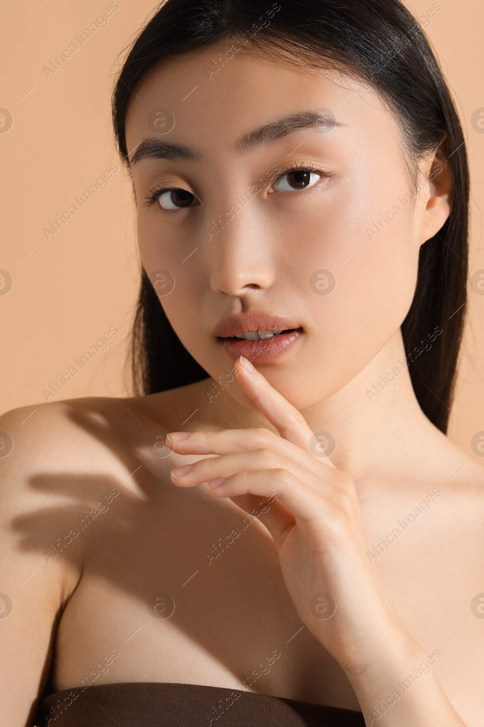Photo of Beautiful young woman with makeup on beige background