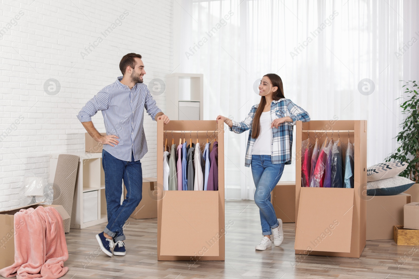 Photo of Young couple near wardrobe boxes at home