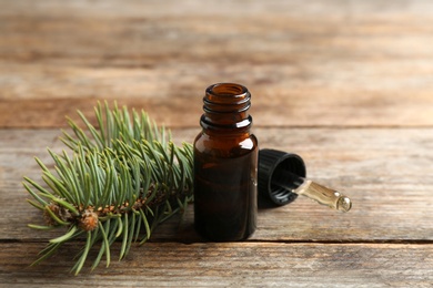 Photo of Composition with bottle of conifer essential oil on wooden table