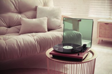 Image of Stylish turntable with vinyl disc in living room