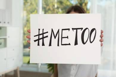 Woman holding paper with text "#METOO" in office. Problem of sexual harassment at work