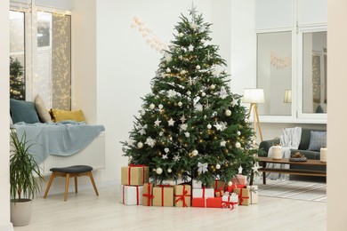 Photo of Beautiful Christmas tree and gift boxes in living room. Interior design