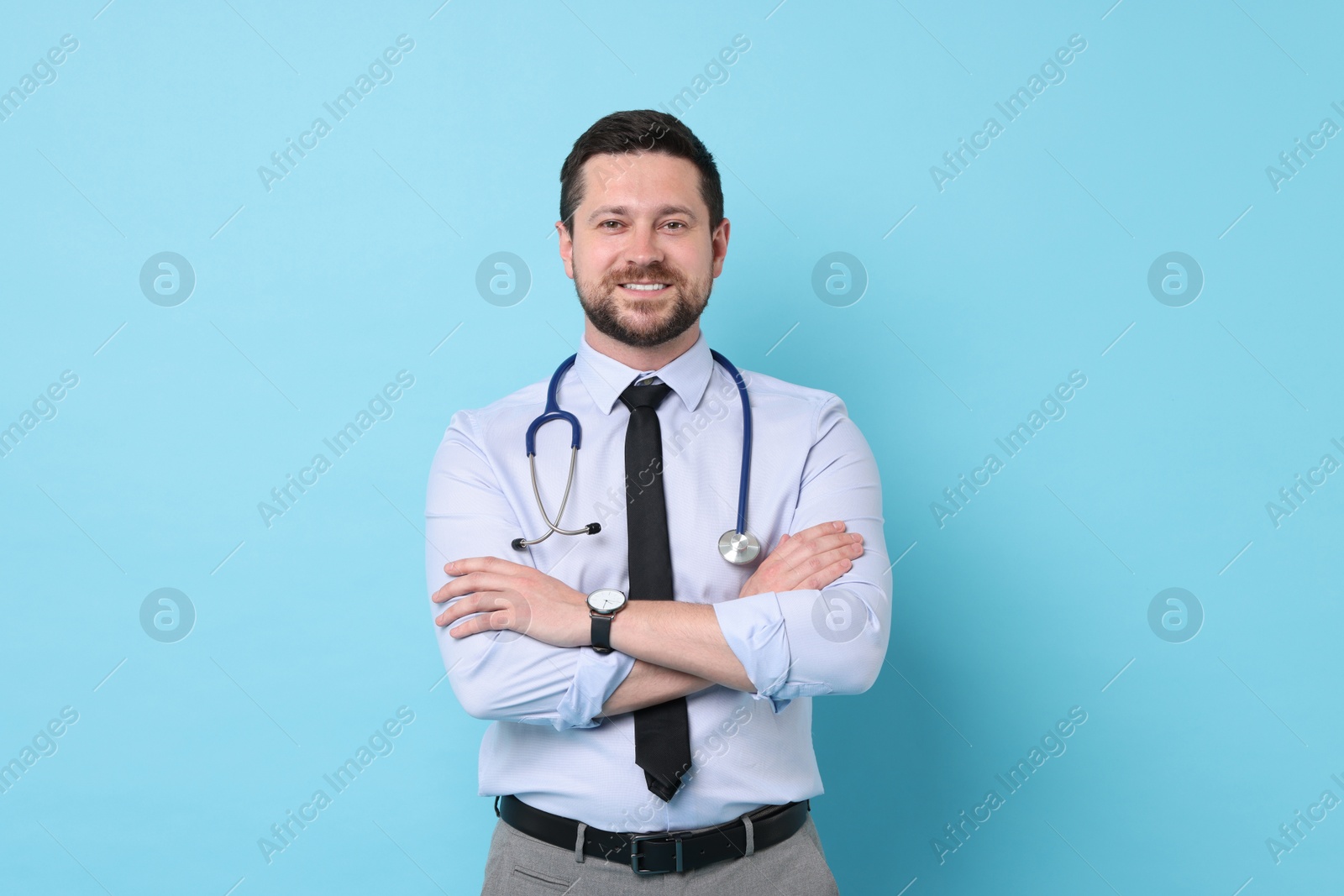 Photo of Portrait of smiling doctor on light blue background