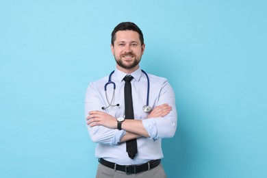 Photo of Portrait of smiling doctor on light blue background