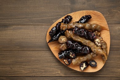 Delicious sweet churchkhelas on wooden table, top view. Space for text