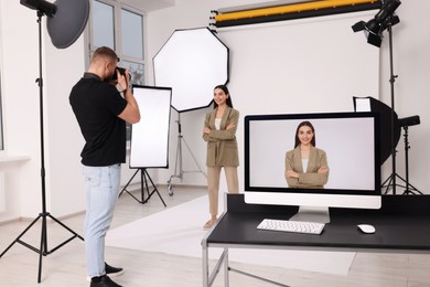 Photo of Professional photographer working with beautiful model in modern photo studio, selective focus