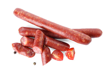Photo of Delicious smoked sausages with tomato and pepper on white background, top view