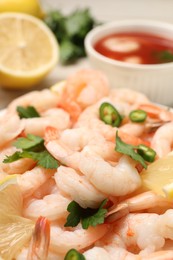 Photo of Tasty boiled shrimps with cocktail sauce, chili and parsley on table, closeup