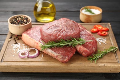 Photo of Pieces of raw beef meat and spices on table, closeup