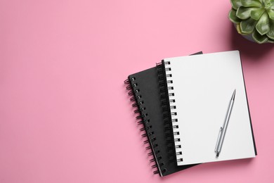 Photo of Flat lay composition with stylish notebooks on pink background, space for text