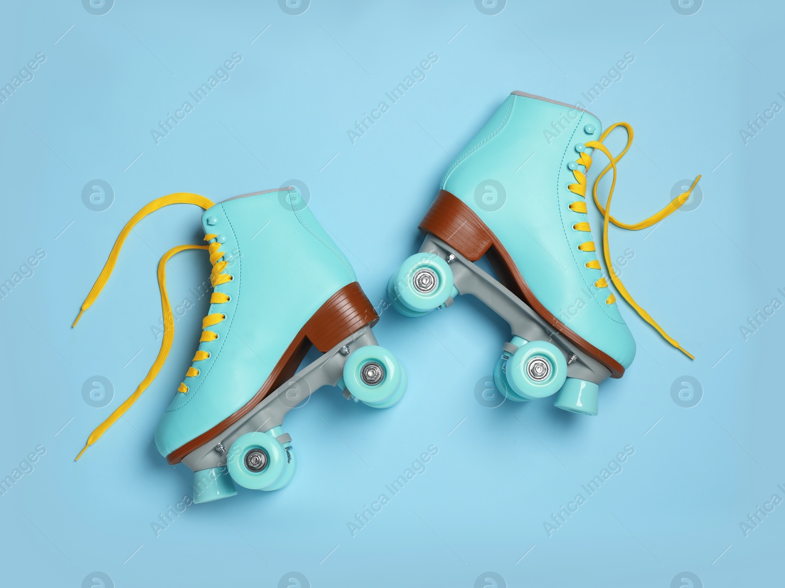 Photo of Pair of stylish quad roller skates on color background, top view