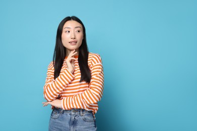 Photo of Portrait of cute woman on light blue background. Space for text