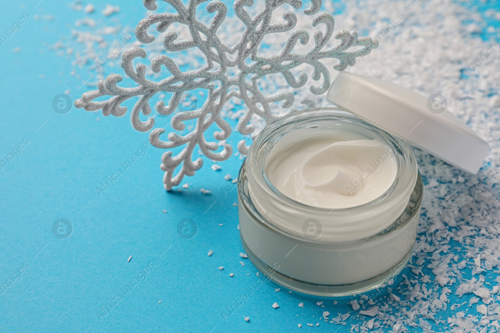 Photo of Tube of hand cream and Christmas decor on light blue background, space for text. Winter skin care