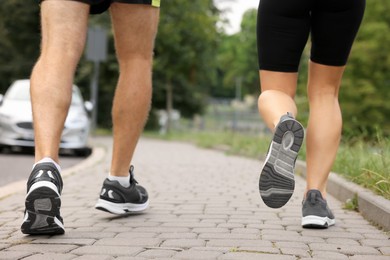 Photo of Healthy lifestyle. Sporty couple running outdoors, closeup