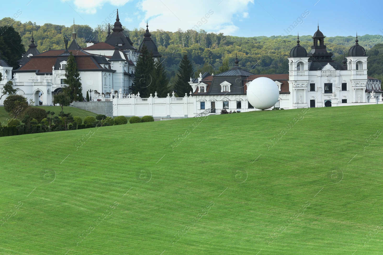 Photo of Beautiful lawn with green grass near white buildings