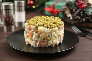 Photo of Traditional russian salad Olivier served on wooden table