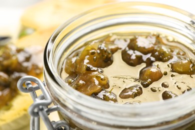 Photo of Jar with delicious gooseberry jam, closeup view