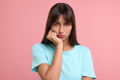 Portrait of resentful woman on pink background