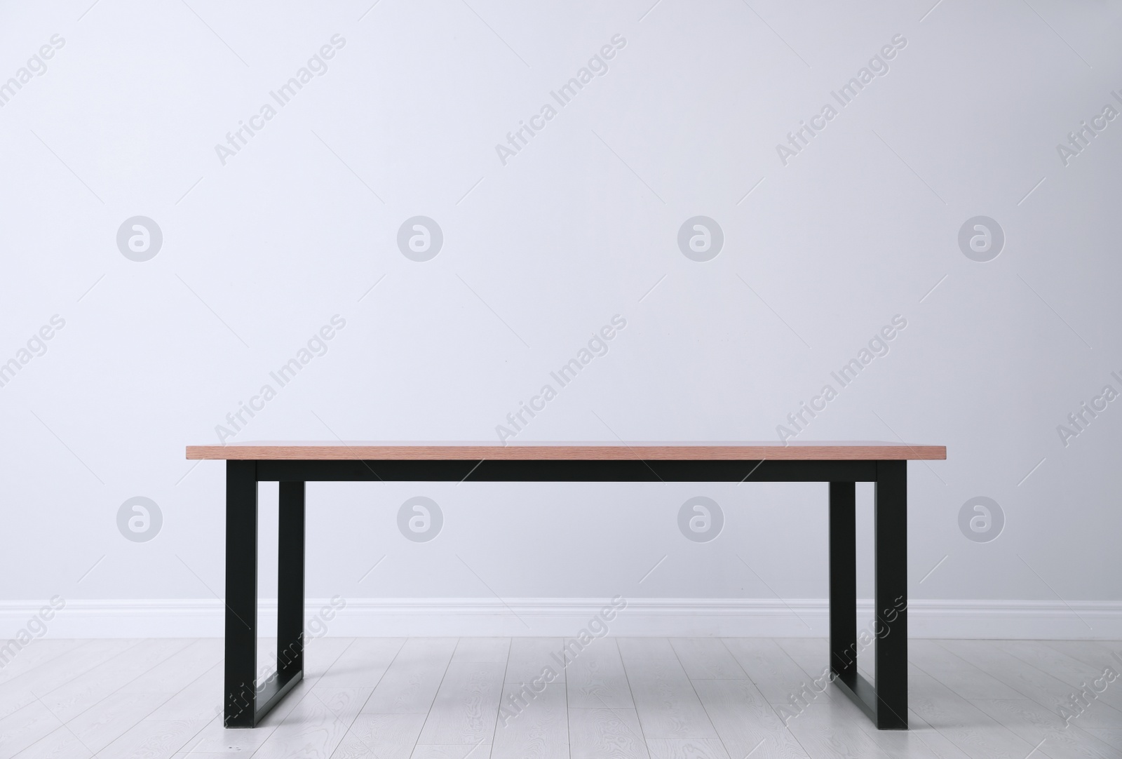 Photo of Wooden table near white wall in room, space for text. Stylish interior design