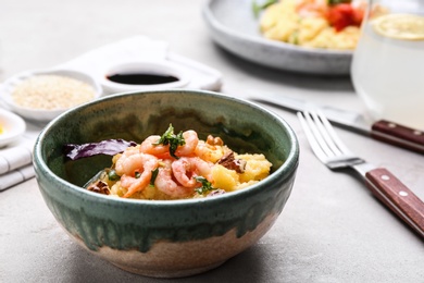 Photo of Bowl with tasty shrimps and grits on table