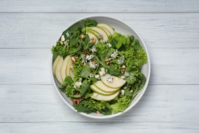 Photo of Fresh salad with pear on white wooden table, top view