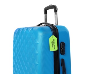 Photo of Blue suitcase with TRAVEL INSURANCE label on white background