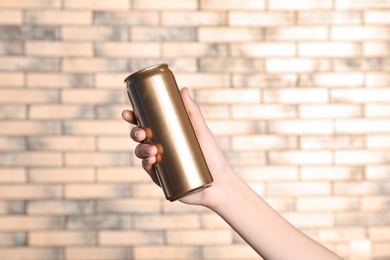 Woman holding aluminum can on blurred background