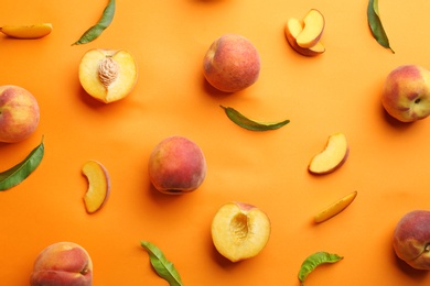 Flat lay composition with fresh peaches on orange background