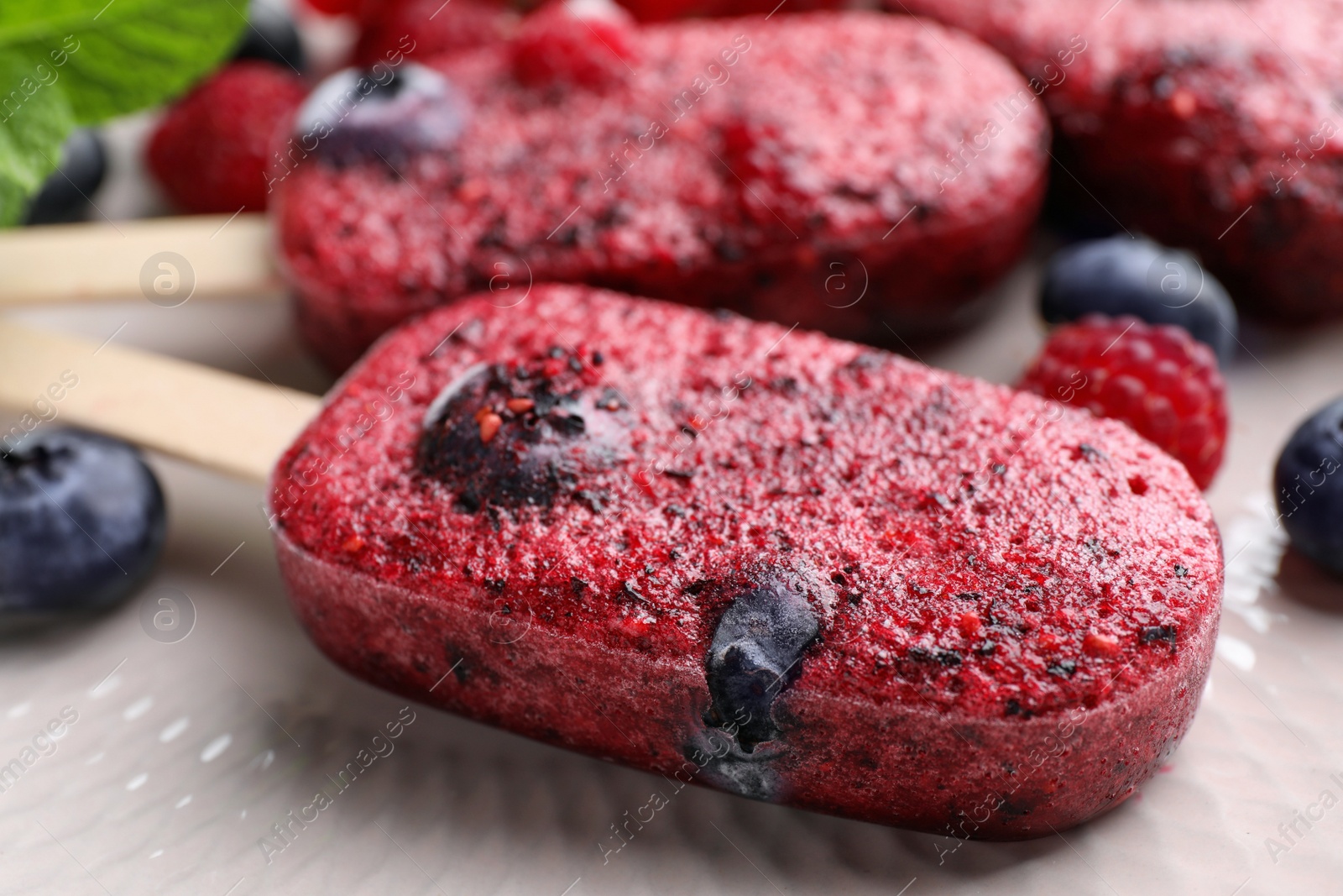 Photo of Tasty berry ice pops on plate, closeup. Fruit popsicle