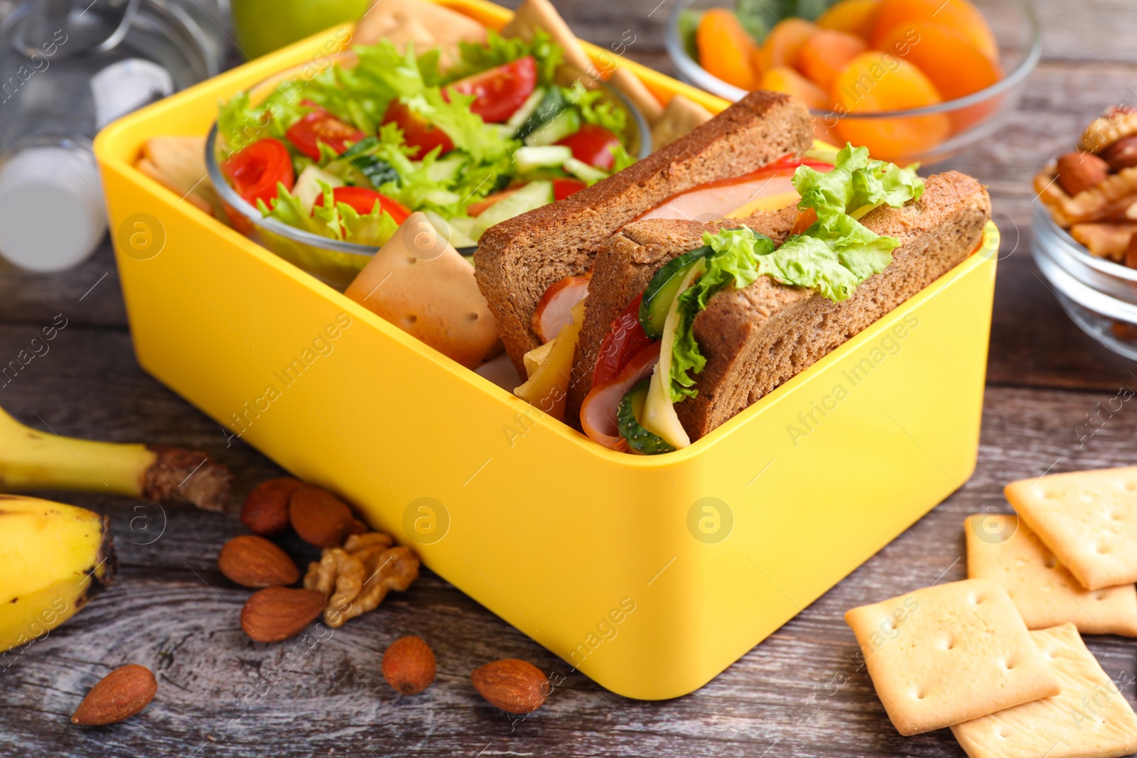 Photo of Lunch box with healthy food for schoolchild on wooden table, closeup