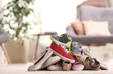 Photo of Heap of different shoes on floor in room. Space for text