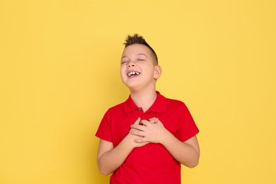 Photo of Portrait of emotional little boy on yellow background