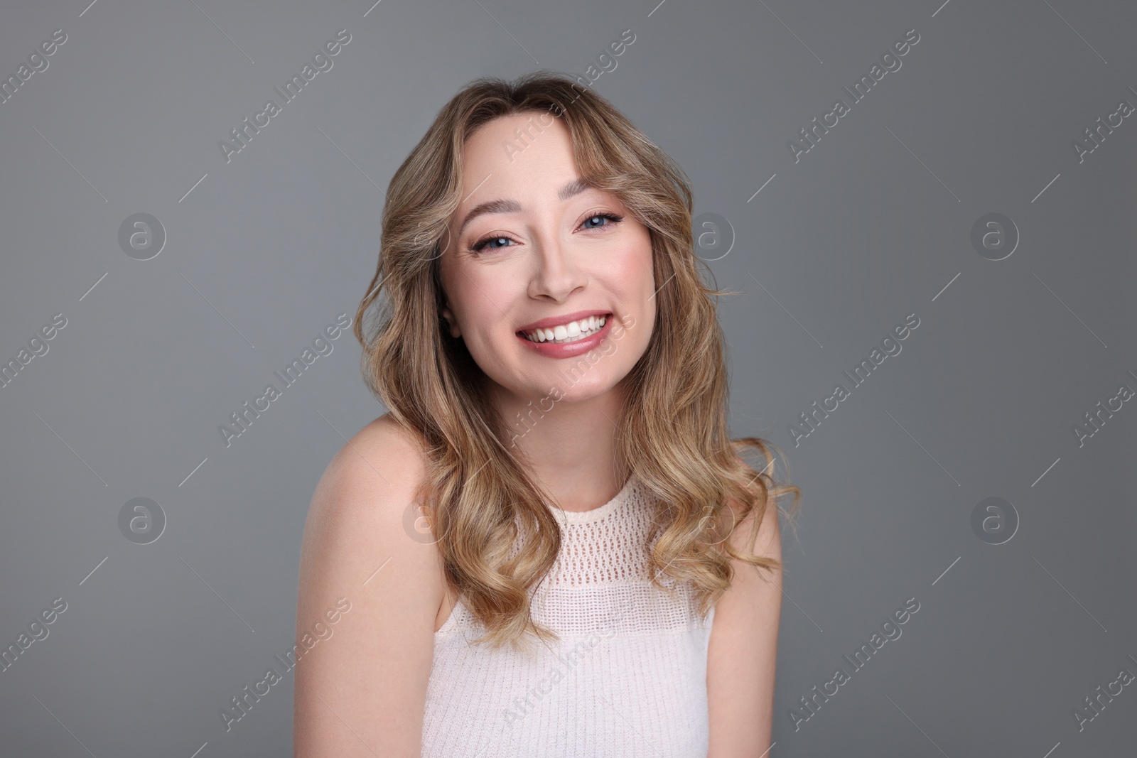 Photo of Portrait of smiling woman on grey background