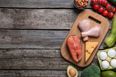 Photo of Flat lay composition with keto diet products on wooden table, space for text