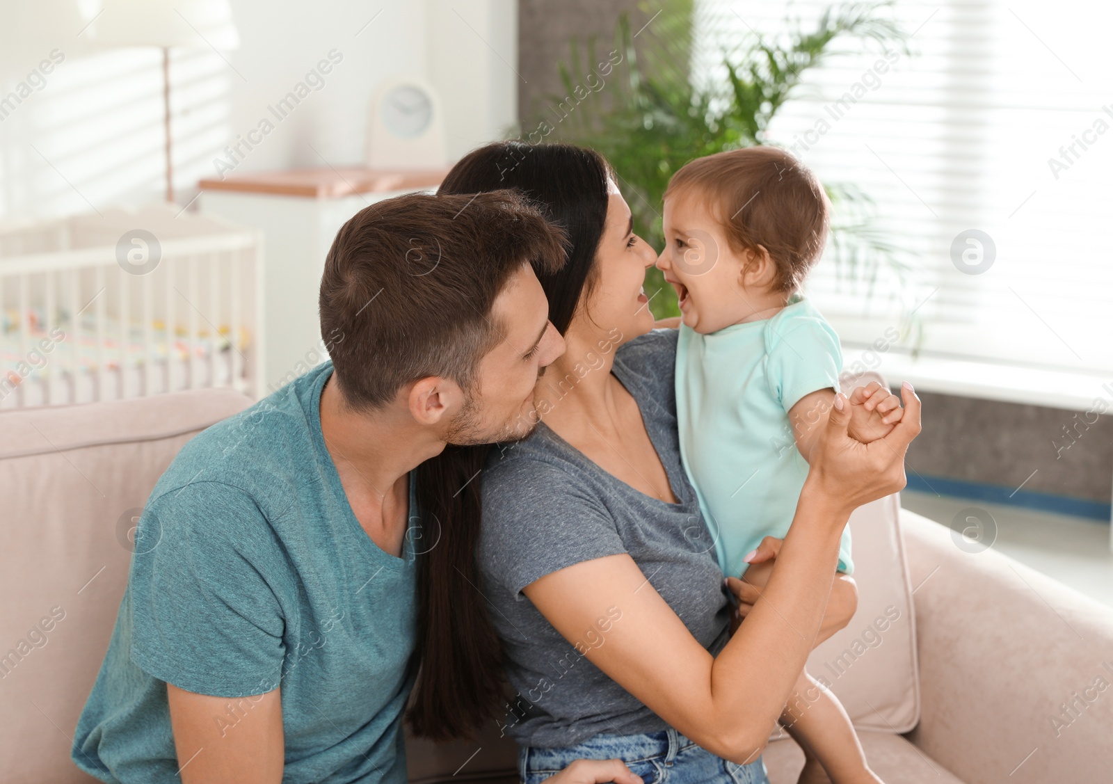 Photo of Happy family with adorable little baby at home