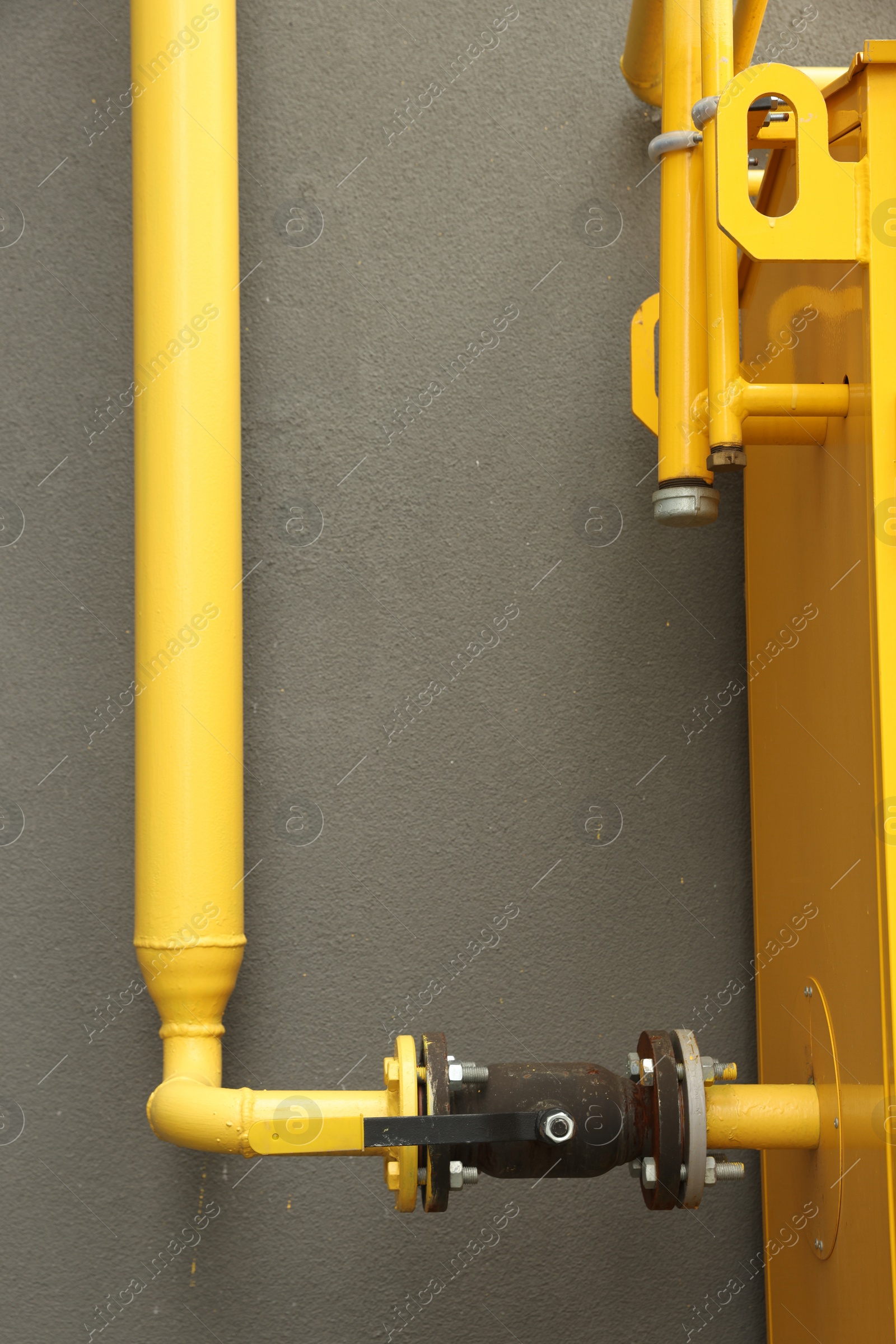 Photo of Yellow gas pipe near brown wall outdoors