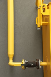 Photo of Yellow gas pipe near brown wall outdoors