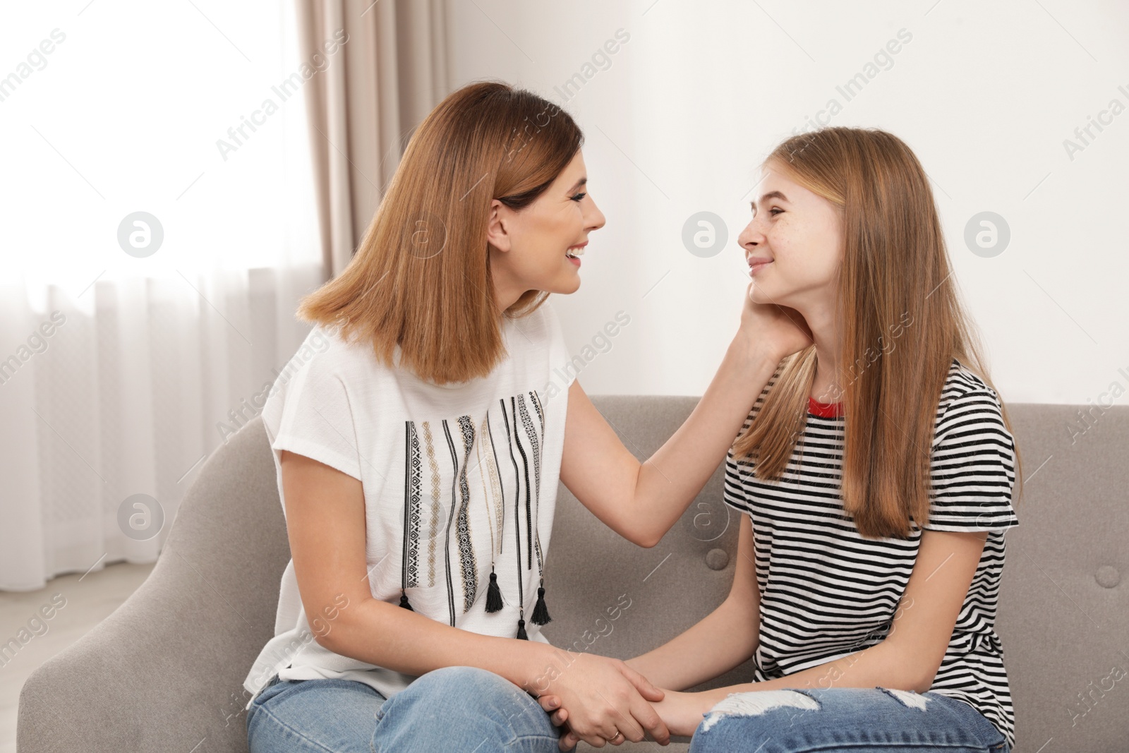 Photo of Happy mother talking with her teenager daughter at home
